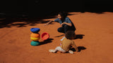 Women and a child are playing outside with Original rainbow classic