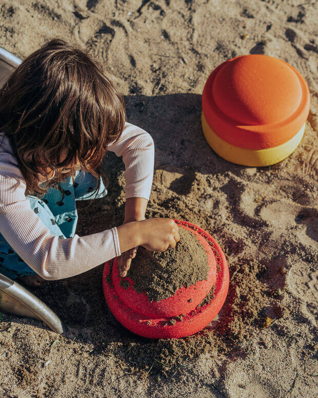 Child plays with stapelstein original warm classic in the sand