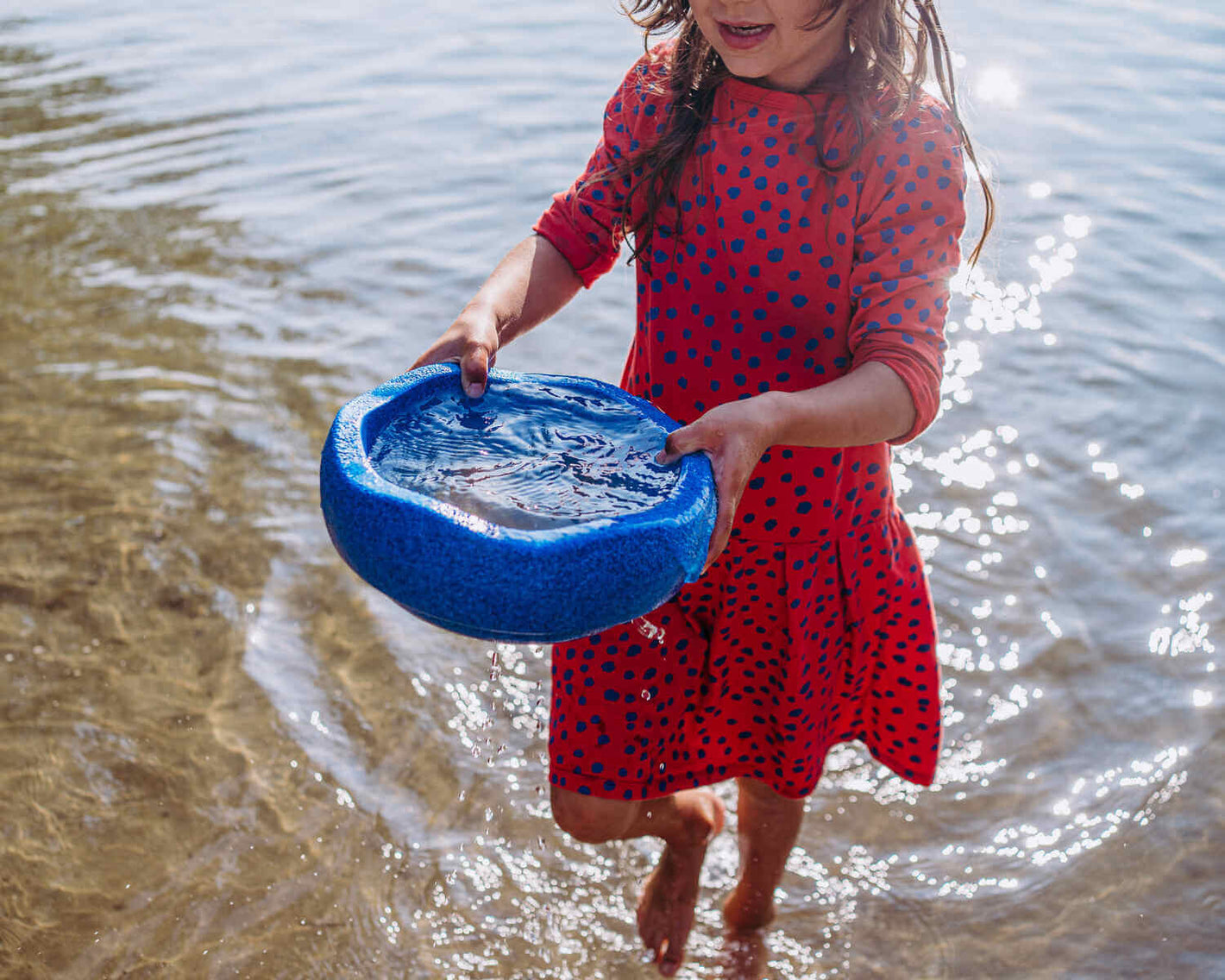 Kid is holding a Original blue filled with water